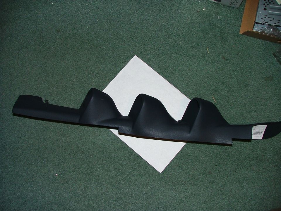 Black molded interior trim panel laid on green carpet