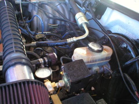 1993 Ford Bronco - Close-up view of a vehicle's engine bay, showing components like the air intake and brake fluid reservoir.