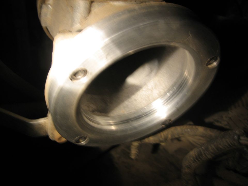 Close-up of a metal pipe fitting with visible threads and bolt holes
