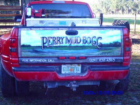1987 Suzuki Samurai - Rear view of a red pickup truck with a custom mural on the tailgate.
