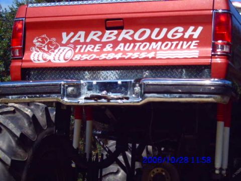 1987 Suzuki Samurai - Rear view of a red pickup truck tailgate with company advertising and a phone number.