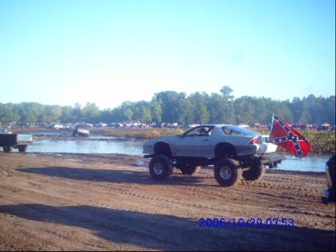 1987 Suzuki Samurai - A modified Chevrolet Camaro with a confederate flag is seen at a mud bog event.