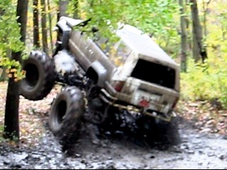 1990 Ford Bronco - A 1990 Ford Bronco navigates a challenging muddy terrain, demonstrating its off-road capabilities.