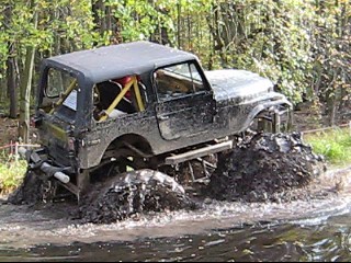 1990 Ford Bronco - Off-road vehicle deep in mud, SuperMotors logo in lower right corner.
