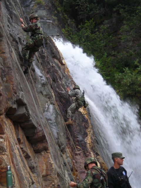 2003 Jeep TJ - Military personnel conduct rappelling training near a waterfall, navigating a challenging rocky terrain.