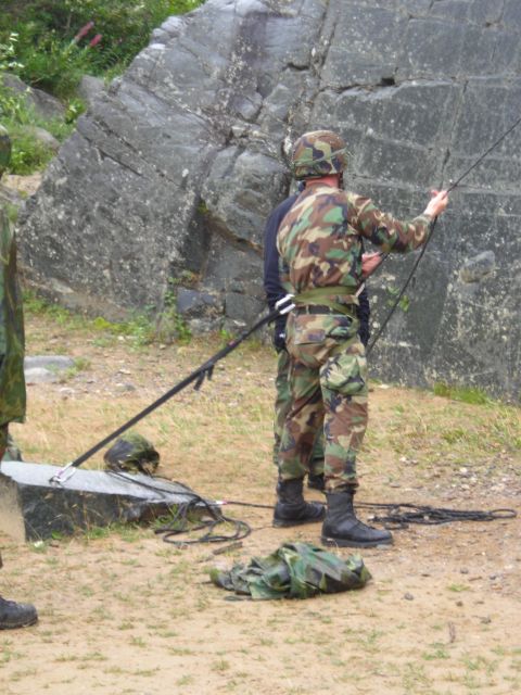 2003 Jeep TJ - Soldiers setting up for a rappelling exercise near a rocky outcrop.