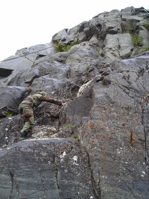 2003 Jeep TJ - A person is shown ascending a challenging rocky incline, highlighting the terrain.
