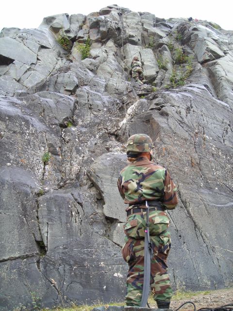 2003 Jeep TJ - Two soldiers are engaged in rock climbing training on a large, cliff.