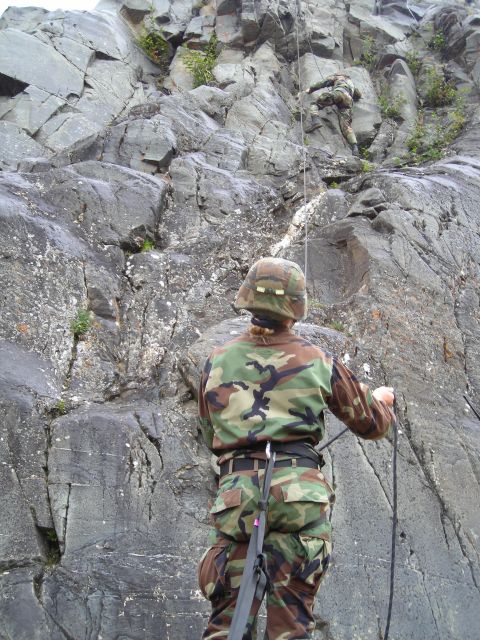 2003 Jeep TJ - Two soldiers in camouflage gear are seen rappelling down a steep, rocky cliff face.