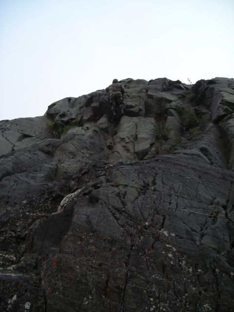 2003 Jeep TJ - A person is rock climbing up a steep, cliff face.