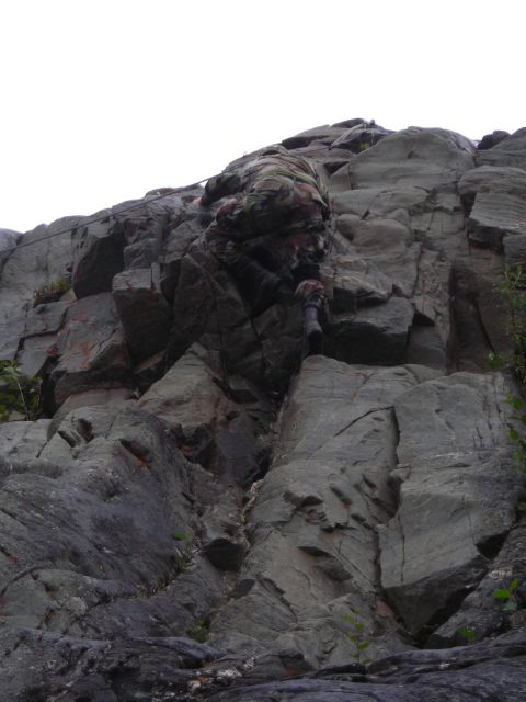 2003 Jeep TJ - A climber ascends a challenging rock formation, using handholds and footholds to navigate the ascent.