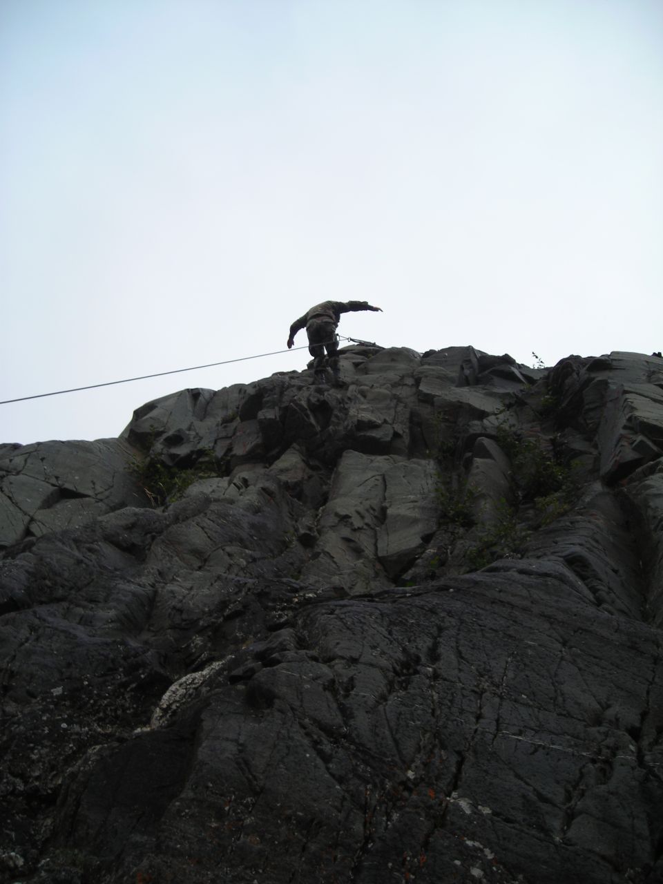 Rock climber on a cliff face with a rope