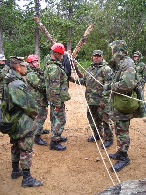 2003 Jeep TJ - Soldiers are engaged in a training exercise involving ropes and logs in a wooded area.