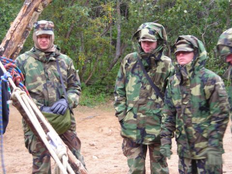 2003 Jeep TJ - Three individuals in camouflage gear stand together outdoors, possibly during a training exercise.