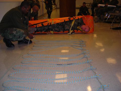 2003 Jeep TJ - People practice a rescue technique with a stretcher and ropes on a polished floor.
