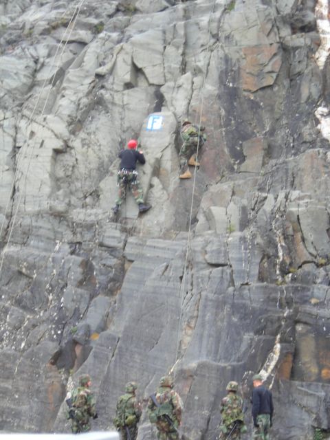 2003 Jeep TJ - Soldiers participate in rock climbing and rappelling training on a steep cliff, with observers below.
