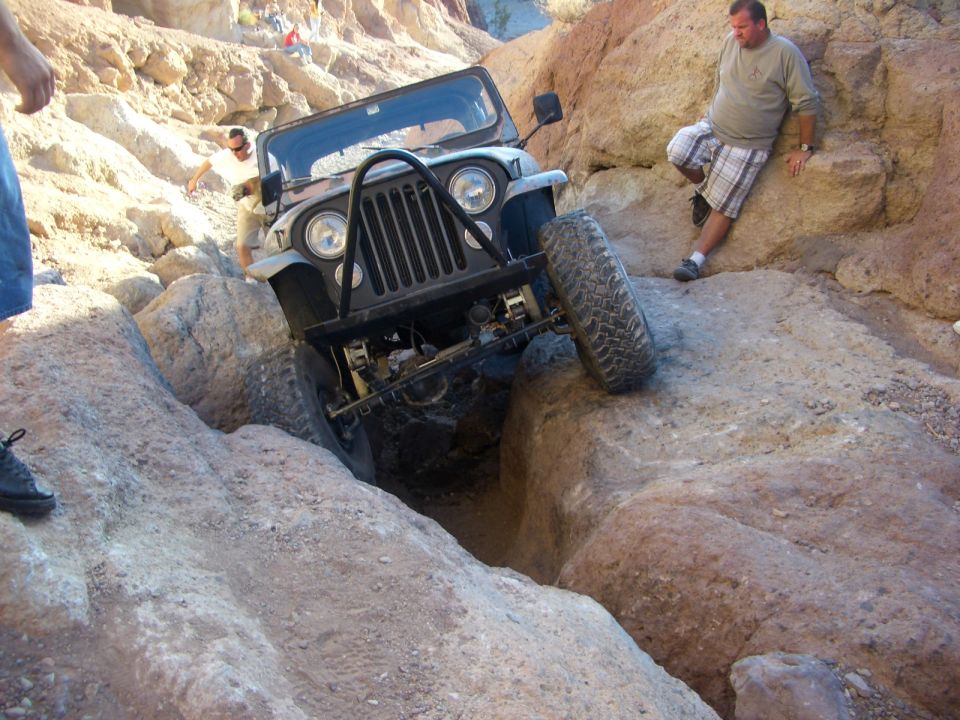 Black Jeep Wrangler navigating a rocky canyon, front view