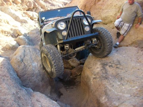 1985 Ford Bronco - A Jeep CJ-7 tackles a challenging rocky trail, demonstrating its off-road capability.
