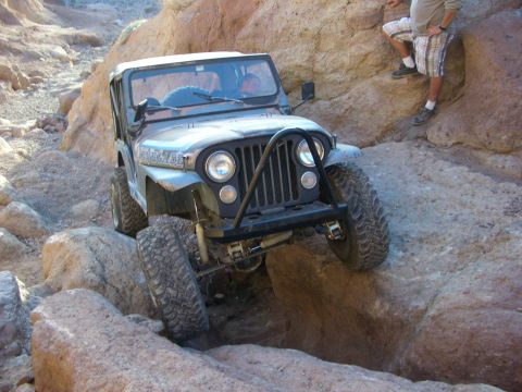 1985 Ford Bronco - Jeep CJ-7 tackling a difficult off-road course in a desert canyon.