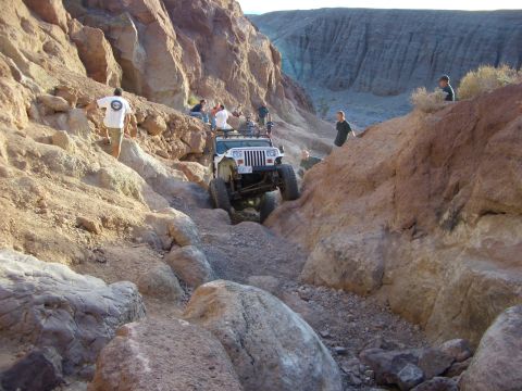 1985 Ford Bronco - Off-roading in a rocky canyon with multiple people present.