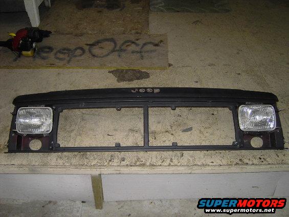 Jeep Cherokee XJ grille with headlights attached. Text on the grille reads 'JEEP'