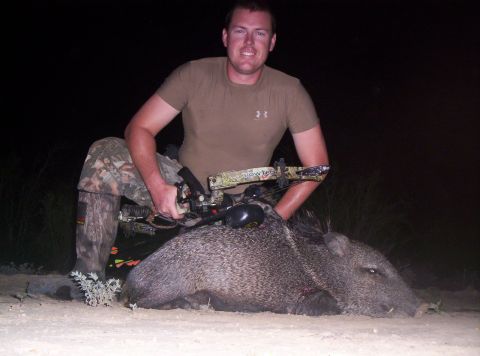2005 BMW 3 Series - A hunter poses with his javelina kill at night.