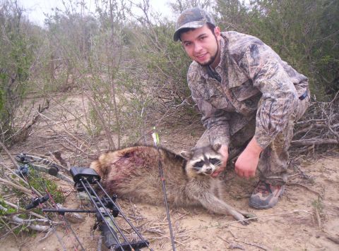 2005 BMW 3 Series - A hunter poses with a raccoon that was taken with a bow and arrow.
