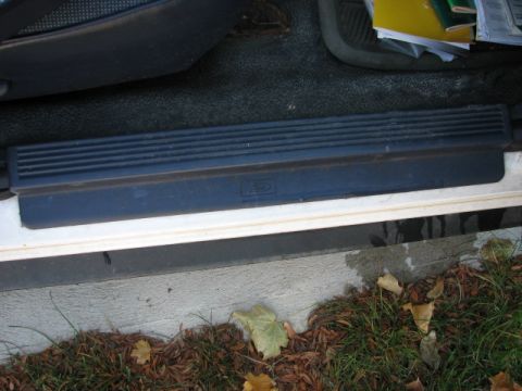2003 Ford Crown Victoria - The interior door sill of a vehicle shows a textured plastic trim piece above the painted lower door frame.