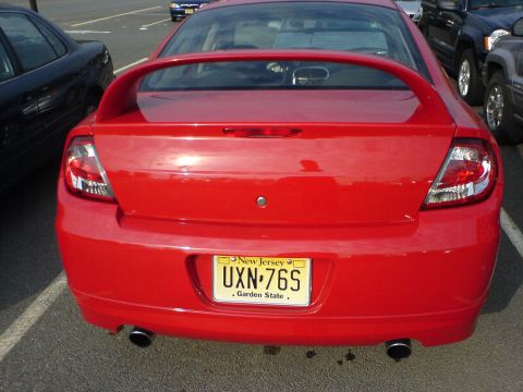 2005 Dodge SRT-4 - Rear view of a red 2005 Dodge SRT-4 sedan parked in a lot. Other vehicles are visible.
