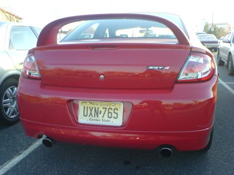 2005 Dodge SRT-4 - This red Dodge Neon SRT-4 is parked in a lot, showing its rear end and a large spoiler.