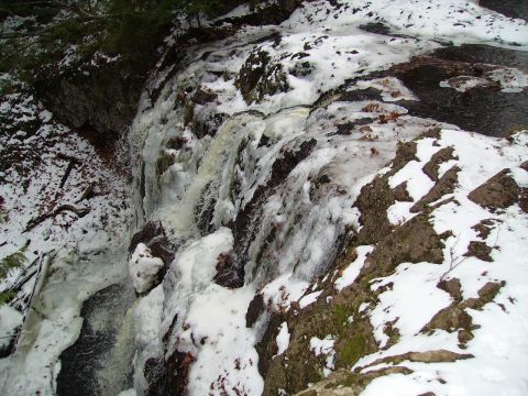 2000 Chevrolet Tahoe - A partially frozen waterfall cascades over rocks covered in snow and ice.