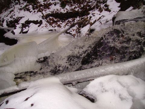2000 Chevrolet Tahoe - A frozen waterfall in a wooded area during winter, with ice and snow covering the rocks and surrounding landscape.