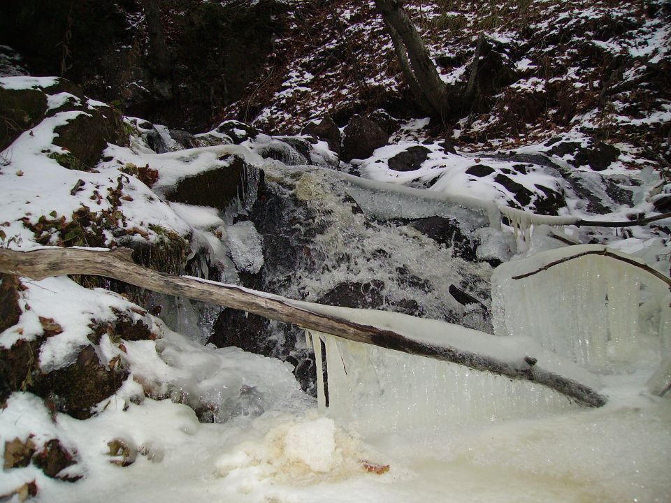 Frozen waterfall with logs and snow, Supermotors.net logo