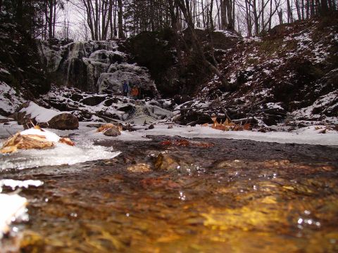 2000 Chevrolet Tahoe - A frozen waterfall and stream in a wooded area during winter.