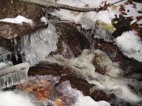 2000 Chevrolet Tahoe - Winter scene of a partially frozen stream with icicles and snow.