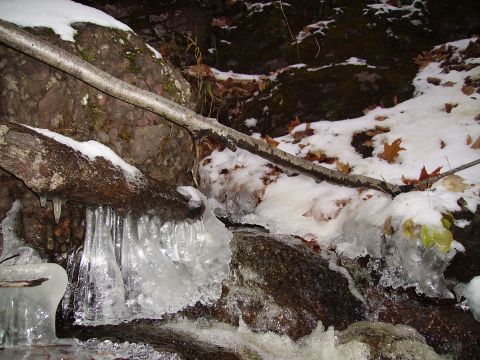 2000 Chevrolet Tahoe - A frozen stream flows over rocks, with icicles and snow covering the surrounding area.