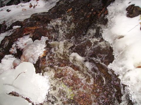 2000 Chevrolet Tahoe - A frozen waterfall with ice formations and flowing water, with a website logo visible.