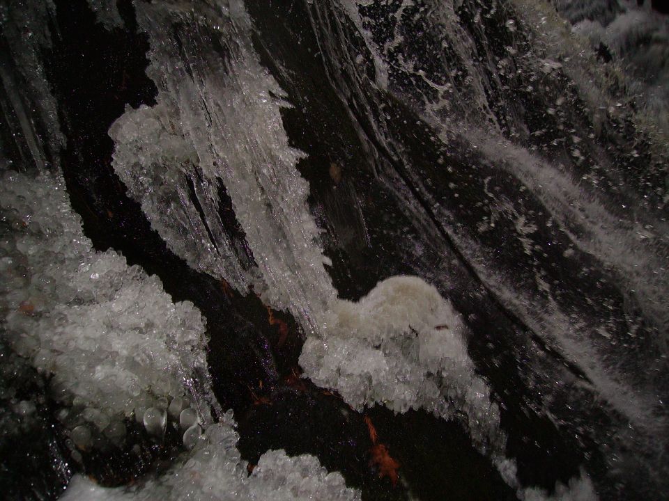 Frozen waterfall with ice formations and water splashes