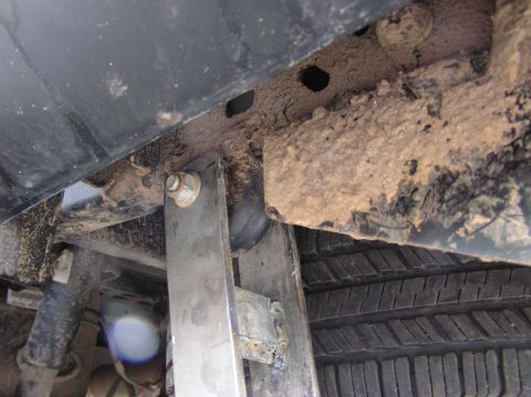 2000 Chevrolet Tahoe - Undercarriage view showing rust, mud, and tire tread on a vehicle.