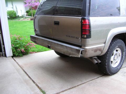 2000 Chevrolet Tahoe - Rear view of a tan Chevrolet Tahoe with a custom metal bumper and dual exhaust pipes.