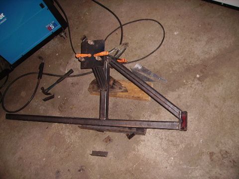 2000 Chevrolet Tahoe - A welding machine and various metal components are laid out on a concrete floor, suggesting a fabrication project.