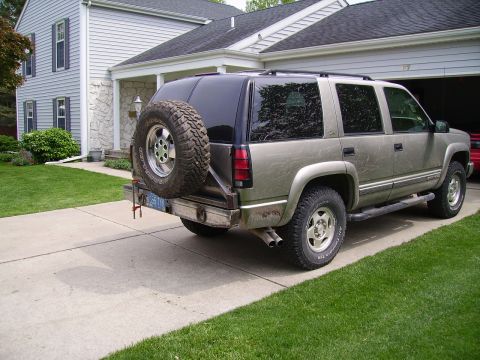 2000 Chevrolet Tahoe - The rear of a Chevrolet Suburban is shown parked in a driveway next to a house.