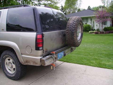 2000 Chevrolet Tahoe - Rear view of a tan Chevrolet Tahoe with a spare tire mounted on the bumper and an aftermarket hitch receiver.