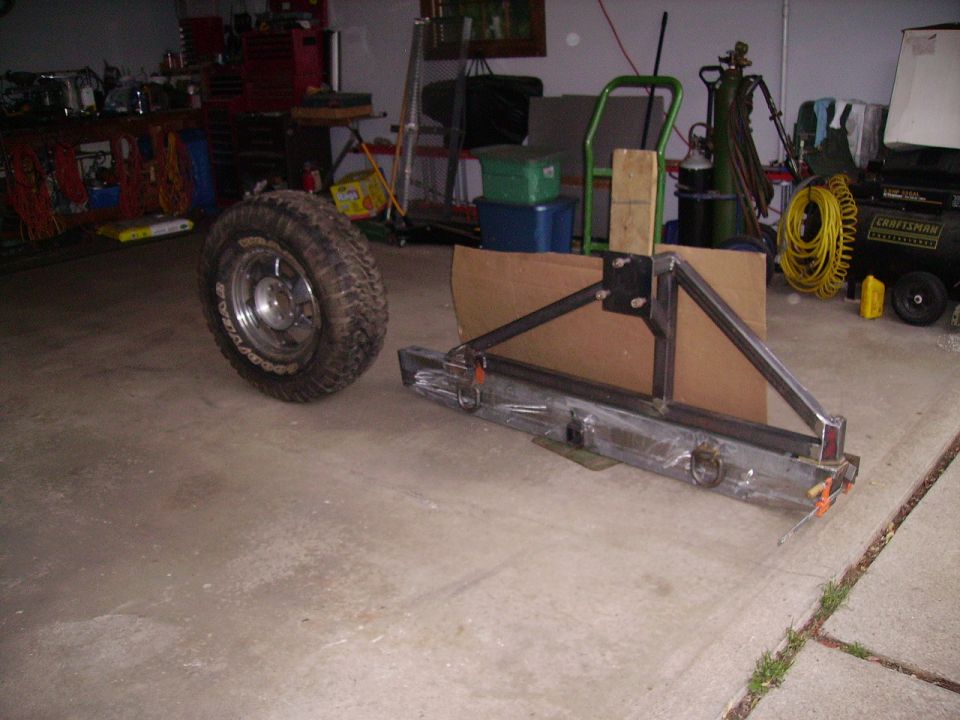 Fabricated steel rear bumper with swing-out tire carrier on a garage floor
