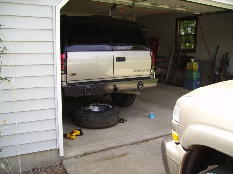 2000 Chevrolet Tahoe - A Chevrolet SUV is parked in a garage with a spare tire on the floor nearby.