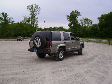 2000 Chevrolet Tahoe - This SUV, likely from the mid-1990s, is parked outdoors on a cloudy day with trees in the background.