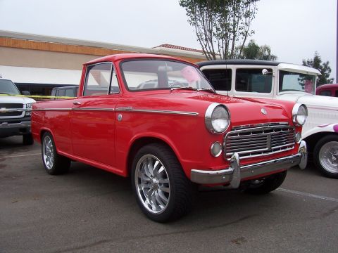 2002 Ford Mustang - A vintage red pickup truck is parked next to other vehicles.