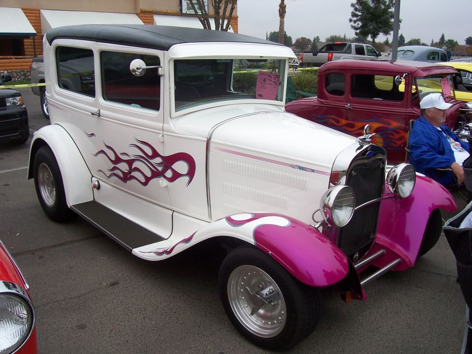 White sedan with purple flames and pink fenders