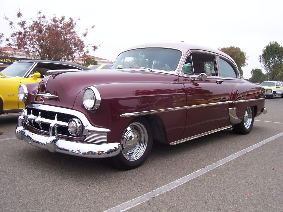 maroon and tan sedan parked next to a yellow car