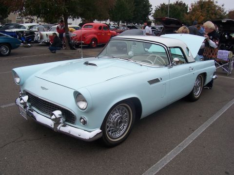 2002 Ford Mustang - A light blue 1955 Ford Thunderbird convertible with a white hardtop is parked at an outdoor event.